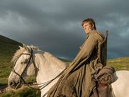 Dans l’ombre de GAME OF THRONES, A KNIGHT OF THE SEVEN KINGDOMS entend changer radicalement de ton et d’échelle. En adaptant les aventures de Dunk et Egg, HBO propose un retour à Westeros plus modeste, plus humain, loin des dragons et des trônes. Une ambition affirmée dès le pilote… au point de provoquer la stupeur de George R. R. Martin lui-même.