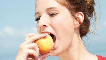 jeune femme mange un fruit